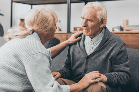 older woman talking to older man who appears confused 