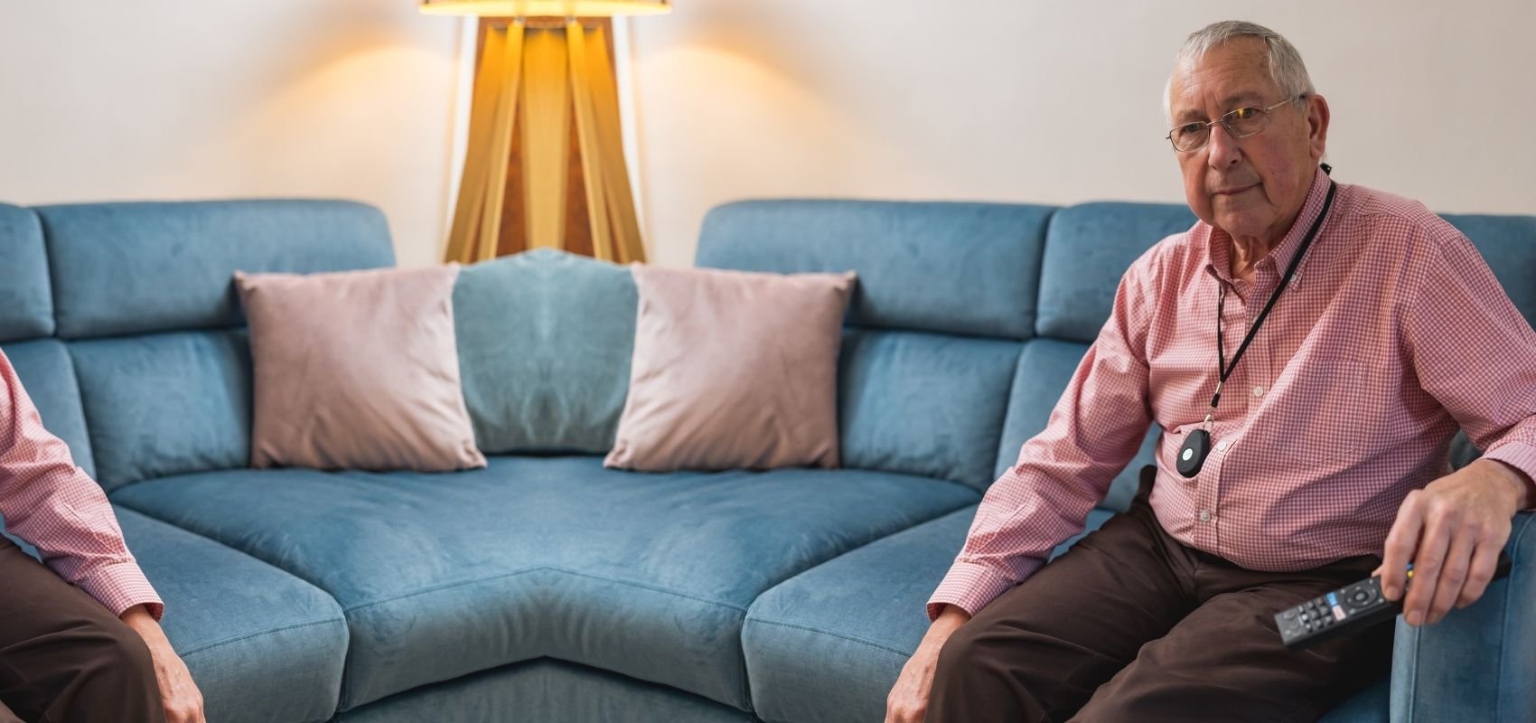 Senior man wearing a HelpAlert pendant alarm at home, ready to call for help in an emergency.