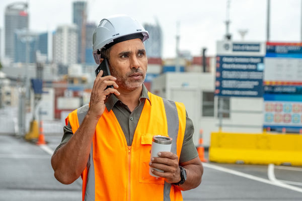 Construction worker taking an emergency phone call at work about his elderly mother