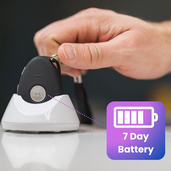 Hand placing a key fob onto a charging station with a '7 Day Battery' icon.