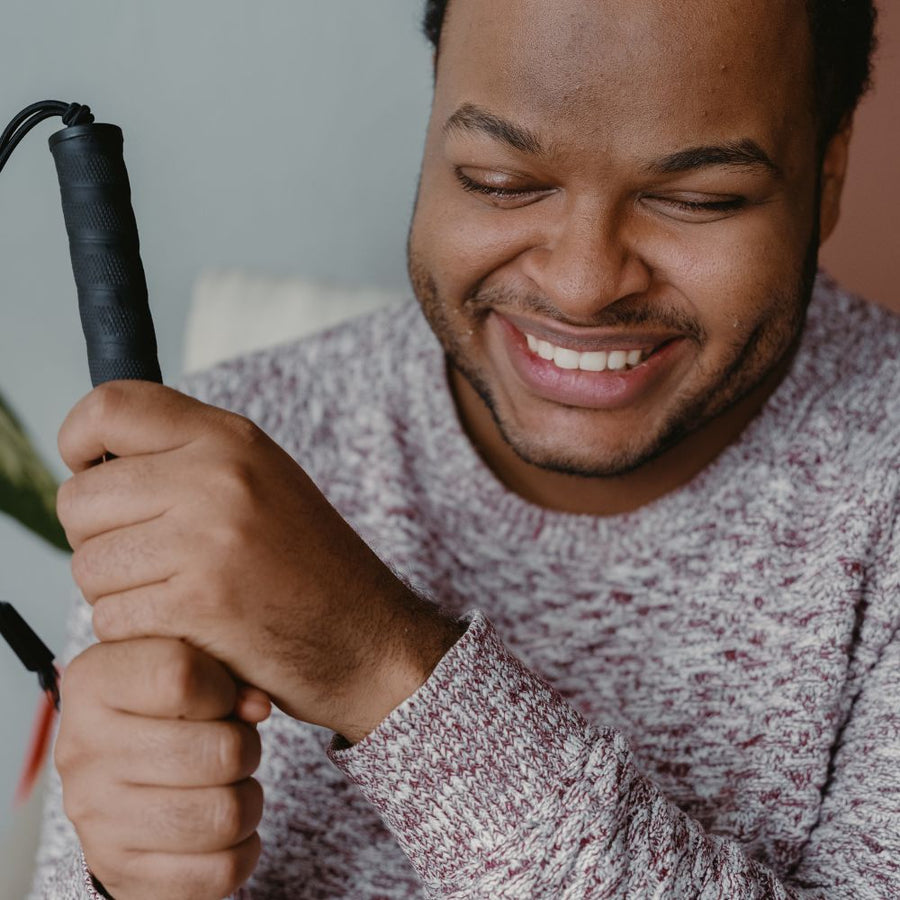 Man holding a white cane, with a neutral background.